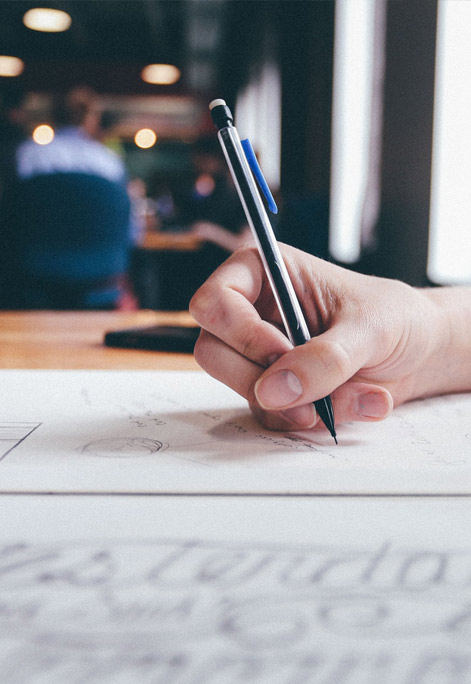 Frau zeichnet in einem Café auf dem Tisch eine Skizze.